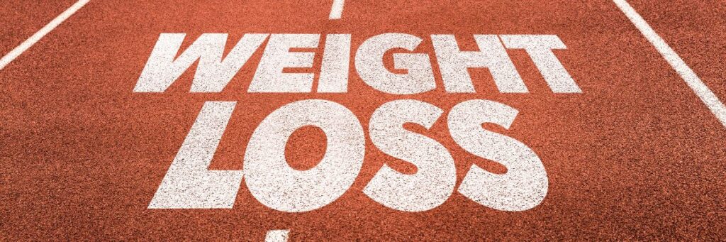 Weight loss text painted on a running track symbolizing fitness motivation and healthy living, related to superfoods for weight loss
