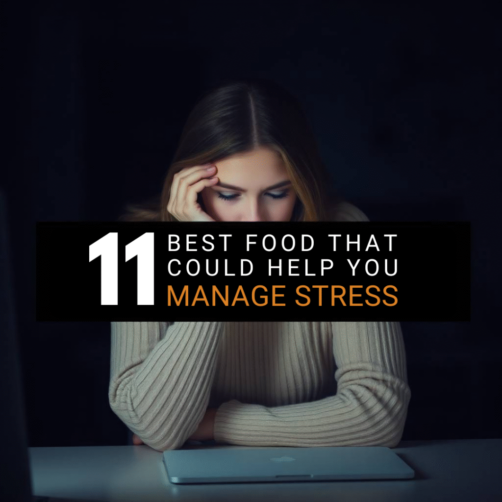Stressed woman holding her head at a desk, with bold text overlay that reads '11 Foods That Could Help You Manage Stress' — promoting healthy nutrition for stress relief
