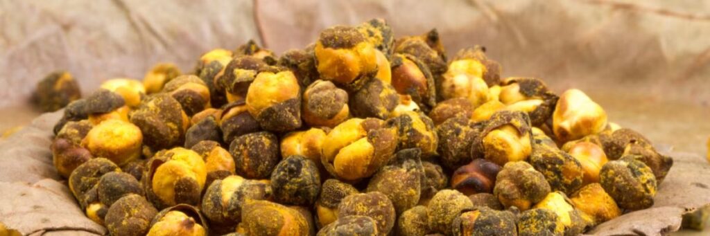 Leaf bowl filled with roasted brown and yellow chana on rustic background