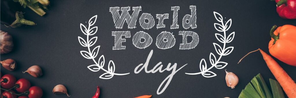 World Food Day banner with fresh vegetables placed around a chalkboard background.