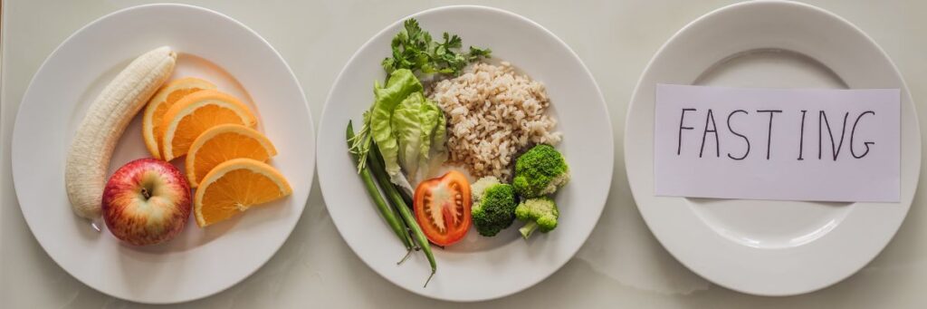 Intermittent fasting meal plates showing fruits vegetables rice and an empty fasting plate